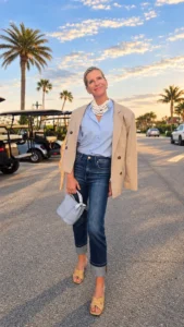 Angela Howenstein wearing a camel blazer, pale blue shirt, cropped jeans and patterned flats.
