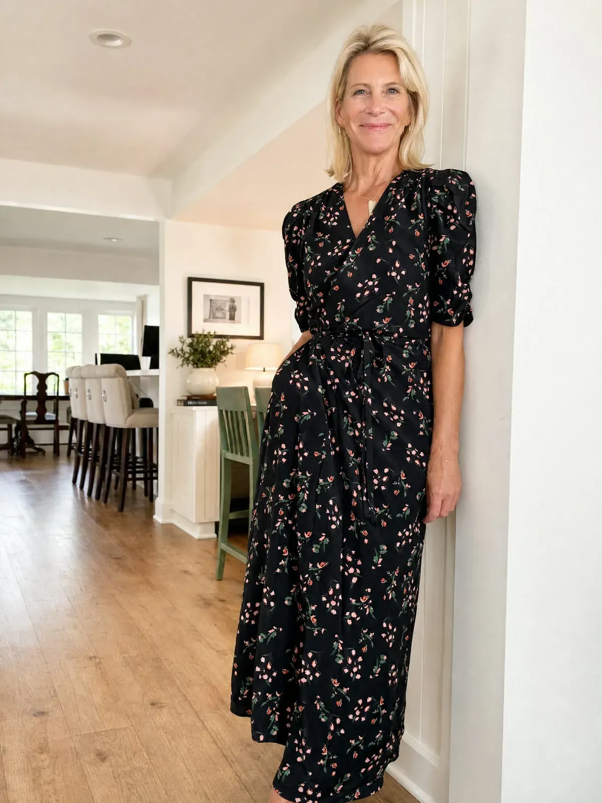 Angela wearing a black floral wrap dress with puff sleeves.