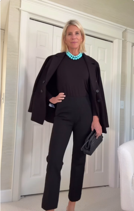 A black jumpsuit with a tailored blazer, turquoise necklace, two-tone heels, and a clutch.