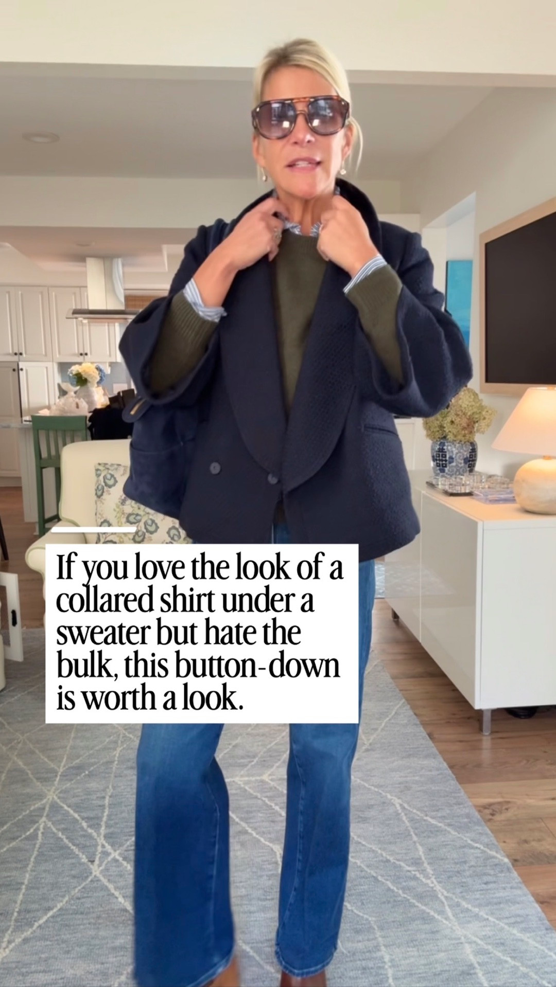 A navy blazer over a collared shirt and dark sweater, paired with jeans.