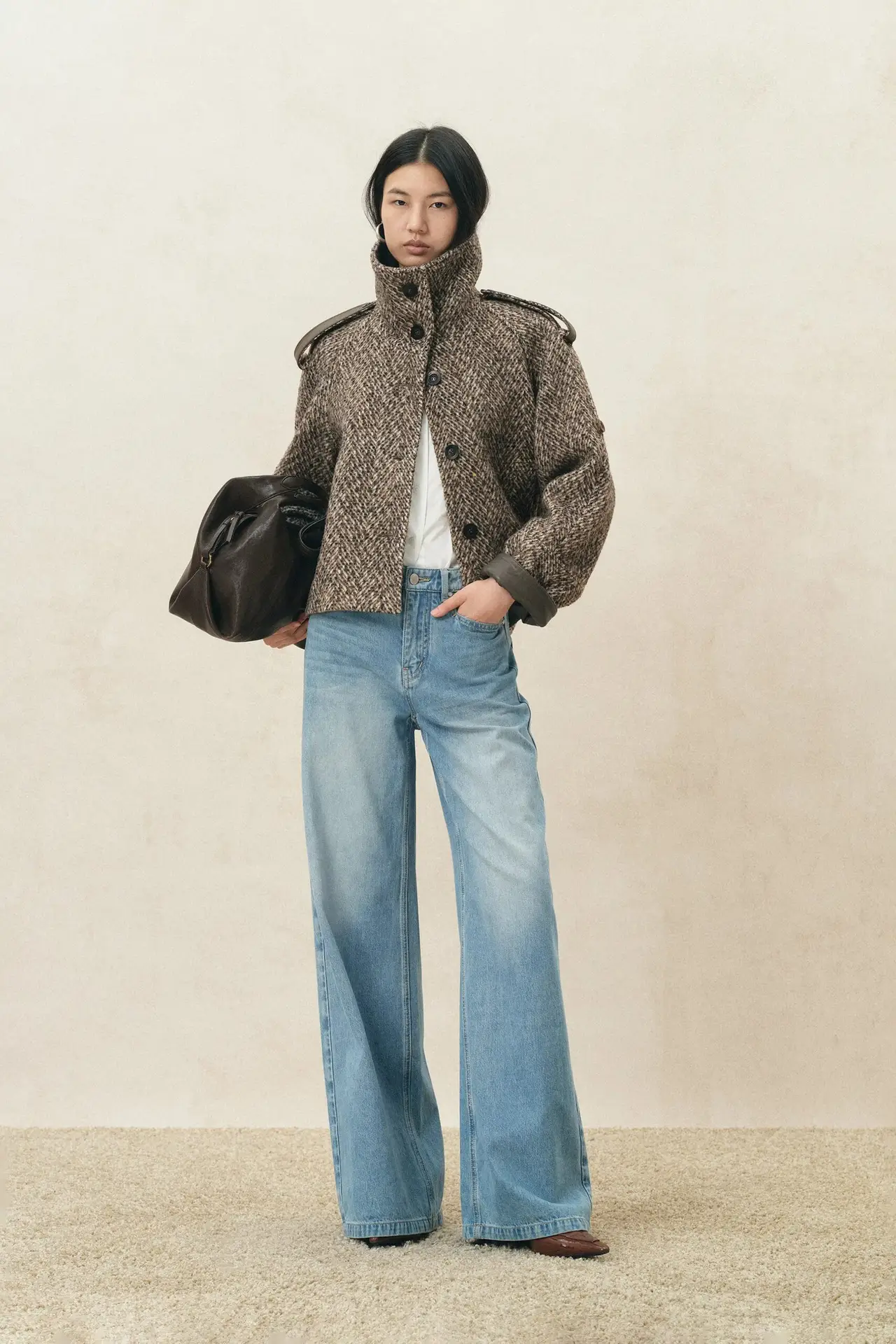 Fabrique model wearing the Willow herringbone cropped coat with light-wash jeans.
